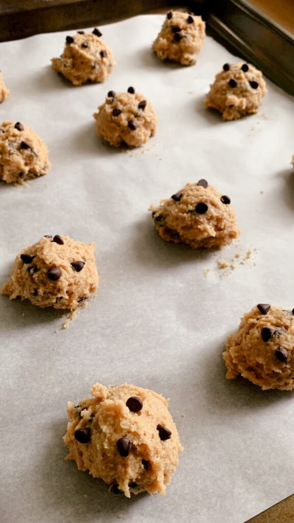 fresh milled chocolate chip cookie dough on a layer of parchment paper on a cookie sheet